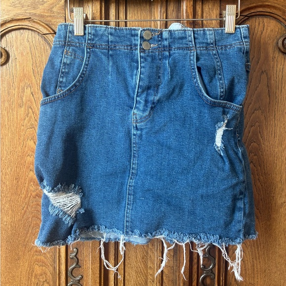 Free People Dresses & Skirts - Free People distressed denim mini skirt with a buckle back and raw hem.